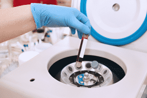 A patient's blood sample being placed into the centrifuge.