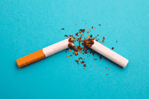 A broken cigarette on a blue backdrop.