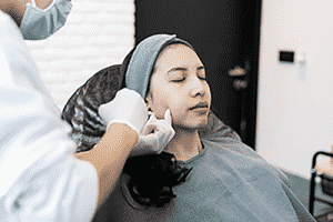 A woman being injected with liquid facelift filler.