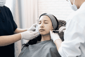 A woman being injected with liquid facelift filler.