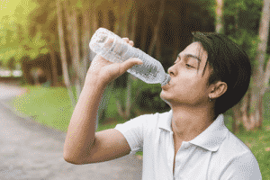 A man drinking from a water bottle.