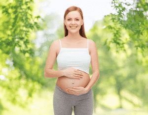 A pregnant woman smiling.